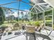 Relaxing screened patio with comfortable furniture and scenic view of the lush backyard and green golf course at 2409 Twickingham Ct, Clermont, FL 34711