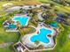 Aerial view of a resort-style pool area with tropical landscaping, lounge chairs, and a well-maintained garden at 2409 Twickingham Ct, Clermont, FL 34711