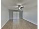 Neutral bedroom with wood-look floors, ceiling fan, and sliding glass door to balcony at 2442 Sweetwater Club Cir # 43, Kissimmee, FL 34746