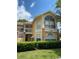 Charming two-story condo with bright yellow exterior, brick pillars, and large windows at 2442 Sweetwater Club Cir # 43, Kissimmee, FL 34746
