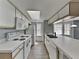 Bright kitchen featuring white appliances, cabinets, and countertops with wood-look floors at 2442 Sweetwater Club Cir # 43, Kissimmee, FL 34746