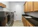 Laundry room featuring stainless steel washer and dryer, cabinets, and countertop space at 2789 Southland St, St Cloud, FL 34772