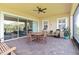 Relaxing covered patio featuring brick flooring, ceiling fan, dining table and chairs, overlooking the backyard at 2789 Southland St, St Cloud, FL 34772
