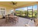Covered patio with a ceiling fan, a wooden dining table, chairs, and outdoor benches with peaceful views at 2789 Southland St, St Cloud, FL 34772