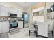 Bright white kitchen features stainless steel appliances, table and chairs, and backyard views at 2808 Osprey Cove Pl # 201, Kissimmee, FL 34746