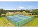 Aerial view of community tennis courts, with green surroundings and residential buildings in the distance at 2808 Osprey Cove Pl # 201, Kissimmee, FL 34746
