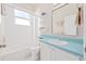 Bright bathroom featuring a tub with white tile surround and a blue vanity top at 2884 Picadilly Cir, Kissimmee, FL 34747
