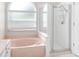 Bathroom featuring separate tub and shower, neutral countertops and ample natural light at 2884 Picadilly Cir, Kissimmee, FL 34747