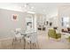 Bright dining area with modern lighting, a glass-top table, and views into the living and kitchen areas at 2884 Picadilly Cir, Kissimmee, FL 34747