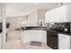 Well-maintained kitchen with white cabinets, black countertops, and stainless steel appliances, opening to the living area at 2884 Picadilly Cir, Kissimmee, FL 34747