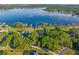 Scenic aerial view of a lakefront property featuring mature trees and a well-manicured lawn at 2926 Marquesas Ct, Windermere, FL 34786