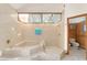 Bright bathroom features a tub and shower combo, tile surround, and a window for natural light at 2926 Marquesas Ct, Windermere, FL 34786