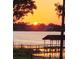 Picturesque waterfront view featuring a dock and the sunset over the calm water at 2926 Marquesas Ct, Windermere, FL 34786