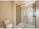 Modern bathroom with a glass-enclosed shower, tiled walls and floor, and a low-flow toilet at 3205 Sonesta Ct # F, Clermont, FL 34711
