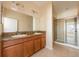 Bathroom featuring double sinks with granite countertops and a glass-enclosed shower, creating a spa-like experience at 3205 Sonesta Ct # F, Clermont, FL 34711