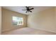 Cozy bedroom featuring a ceiling fan and a large window with blinds, offering plenty of natural light at 3205 Sonesta Ct # F, Clermont, FL 34711