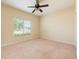 Bright bedroom features a ceiling fan, neutral carpet, and a window bringing in natural light at 3205 Sonesta Ct # F, Clermont, FL 34711