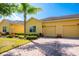 Charming yellow single-Gathering home with a two-car garage, lush landscaping, and a brick driveway on a sunny day at 3205 Sonesta Ct # F, Clermont, FL 34711