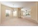 Spacious living room with neutral carpet, chandelier, and ample natural light from the sliding door at 3205 Sonesta Ct # F, Clermont, FL 34711