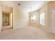 Spacious living room with neutral carpet, chandelier, and ample natural light from the window at 3205 Sonesta Ct # F, Clermont, FL 34711