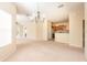 Open concept living area with a view of the kitchen, neutral carpet, and sliding door to a screened lanai at 3205 Sonesta Ct # F, Clermont, FL 34711