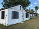 Exterior of a white house with dark trim and peeling paint, set in a grassy yard at 3772 Cochran St, Apopka, FL 32703
