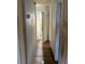 Narrow hallway with wood floors and beadboard walls, leading to rooms in the house at 3772 Cochran St, Apopka, FL 32703
