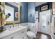 This bathroom includes a vanity with marble countertop, white wainscoting, and gold fixtures at 427 Egret Place Dr, Winter Garden, FL 34787