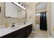 Bathroom with dual sinks, granite countertops, a large mirror, and a shower with a curtain at 427 Egret Place Dr, Winter Garden, FL 34787
