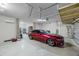 Spacious garage with a red convertible car, bright lighting, and ample storage space for tools and equipment at 427 Egret Place Dr, Winter Garden, FL 34787