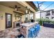 Well-equipped outdoor kitchen with bar seating, a grill, a fridge, and ample counter space for entertaining at 427 Egret Place Dr, Winter Garden, FL 34787