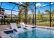 Captivating pool offers in-water lounge chairs and tropical views within a secure, screened-in backyard setting at 427 Egret Place Dr, Winter Garden, FL 34787