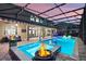 Stunning pool with a fire feature, a bar, and a covered area with a couch for lounging and entertainment at 427 Egret Place Dr, Winter Garden, FL 34787