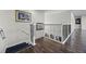 Upstairs hallway with elegant iron railing, dark wood floors, and decorative artwork at 427 Egret Place Dr, Winter Garden, FL 34787