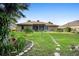 Backyard view with lush lawn, pathway, and screened porch at 453 Kettering Rd, Deltona, FL 32725