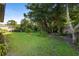 Backyard with mature trees and manicured lawn, offering a serene and private outdoor space at 453 Kettering Rd, Deltona, FL 32725