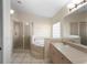 Bright bathroom features a walk-in shower, soaking tub, neutral tiling, and a vanity with ample storage at 453 Kettering Rd, Deltona, FL 32725