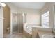 Bright bathroom featuring a soaking tub, a walk-in shower, and tiled floors at 453 Kettering Rd, Deltona, FL 32725