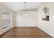 Elegant dining room featuring hardwood floors, a modern chandelier, and a large window offering abundant natural light at 453 Kettering Rd, Deltona, FL 32725