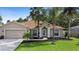 Beautifully landscaped home featuring mature palms, a well-kept lawn, and a classic facade at 453 Kettering Rd, Deltona, FL 32725