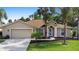 Charming single-story home with a manicured lawn, mature trees, and an attached two-car garage at 453 Kettering Rd, Deltona, FL 32725