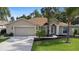 Charming single-story home with a manicured lawn, mature trees, and an attached two-car garage at 453 Kettering Rd, Deltona, FL 32725