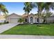 Charming single-story home with a manicured lawn, mature trees, and an attached two-car garage at 453 Kettering Rd, Deltona, FL 32725
