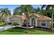 Charming single-story home with a manicured lawn, mature trees, and an attached two-car garage at 453 Kettering Rd, Deltona, FL 32725