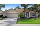 Charming single-story home with a manicured lawn, mature trees, and an attached two-car garage at 453 Kettering Rd, Deltona, FL 32725