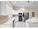 Well-equipped kitchen featuring white cabinets, stainless steel appliances, and tiled backsplash for easy maintenance at 453 Kettering Rd, Deltona, FL 32725