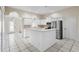 Bright kitchen featuring white cabinetry, tile flooring, stainless steel appliances, and a center island at 453 Kettering Rd, Deltona, FL 32725