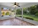 Inviting screened porch with tile flooring, offering serene views of the lush, green backyard and providing shade at 453 Kettering Rd, Deltona, FL 32725