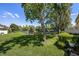 Well-manicured backyard featuring lush green grass and serene pond views and mature trees, creating a private and tranquil oasis at 484 Harbor Winds Ct, Winter Springs, FL 32708