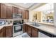 Well-lit kitchen featuring stainless steel appliances, generous counter space, and an opening to the dining area at 484 Harbor Winds Ct, Winter Springs, FL 32708